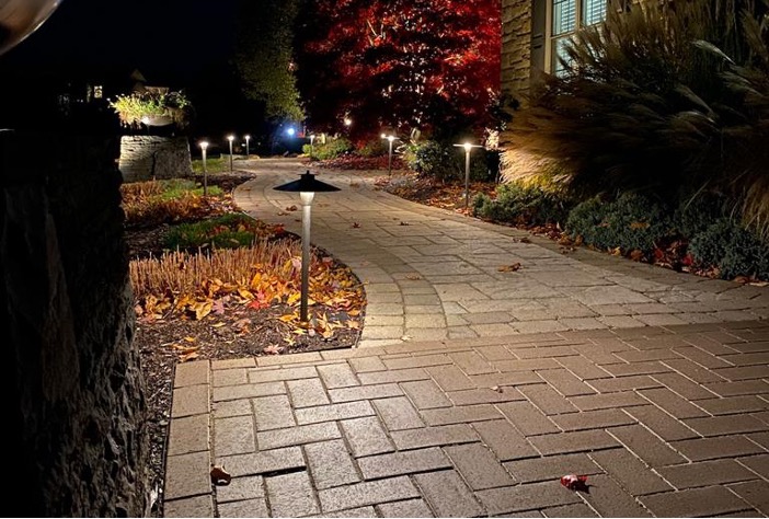 Illuminated pathway with soft garden lights at night.