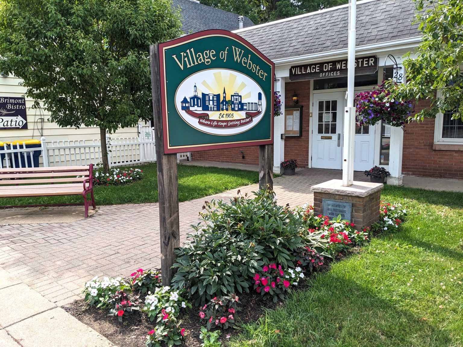 Village of Webster sign with flowers outside town offices