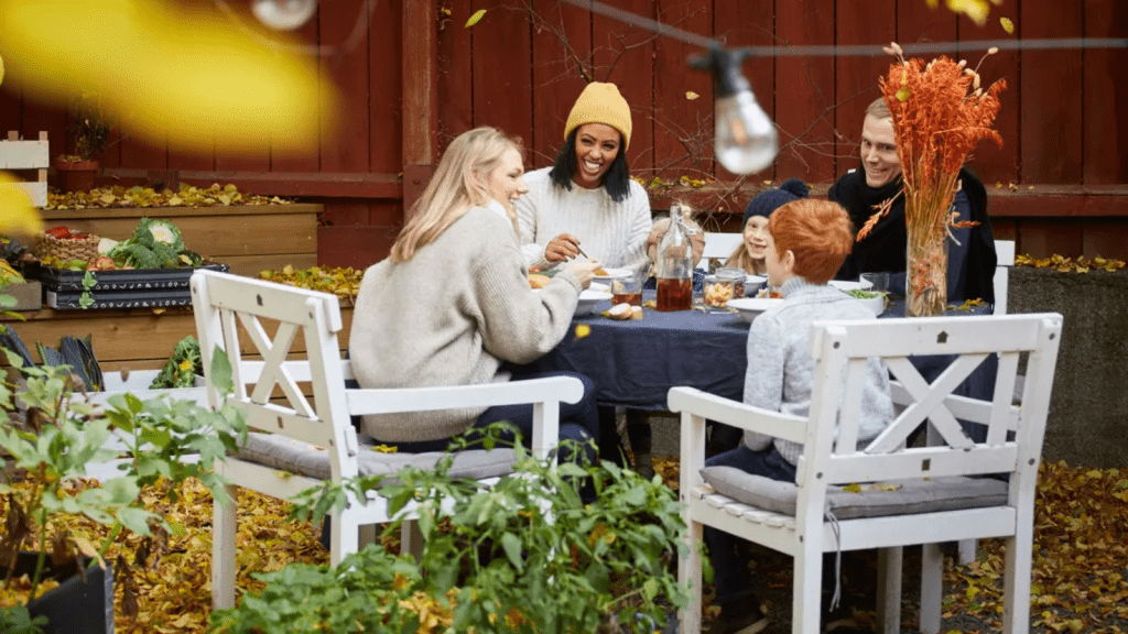 Family enjoying outdoor fall meal with autumn decor